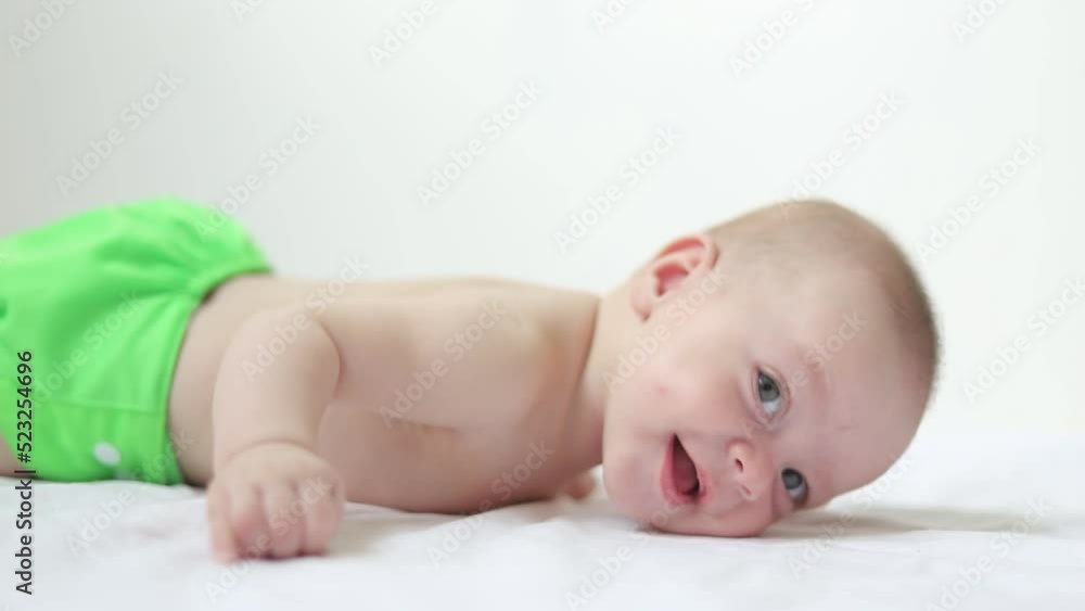 The baby learns to hold the head . The baby is 0-3 months old. An infant. Skilful kids. The baby learns to hold the head . The baby is 0-3 months old. An infant. Skilful kids.