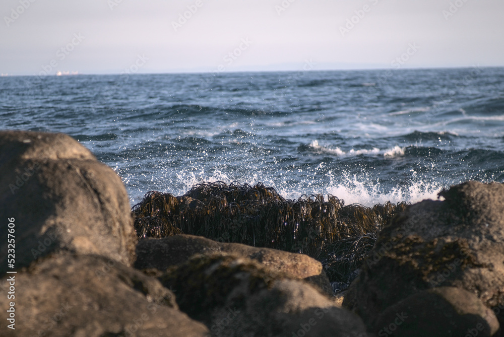 olas que rompen en las rocas, puesta de sol