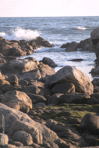 durante el ocaso se ven las olas rompiendo en las rocas de la playa