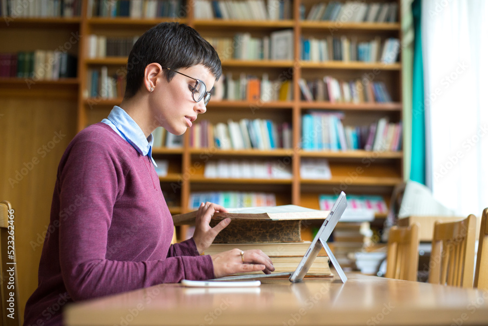 Young woman student reading books and studying in the library Young woman student reading books and studying in the library