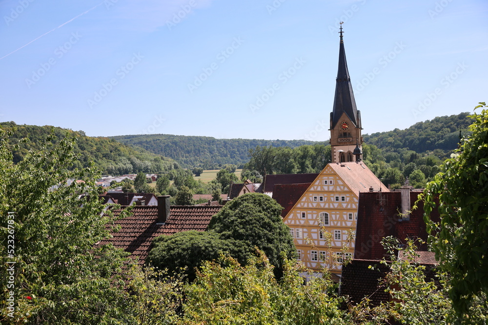 Scenic view of old German village with church, big old fachwerk house and greenery Scenic view of old German village with church, big old fachwerk house and greenery
