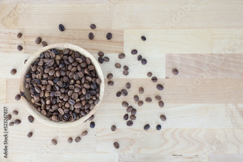 Coffee beans on the wooden table in the wooden plate. Brown coffee beans 