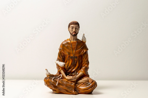 Statue of Saint Francis of Assisi. Statuette of Saint Francis of Assisi meditating. Padmasana pose. Lotus asana. Asana Padmasana photo