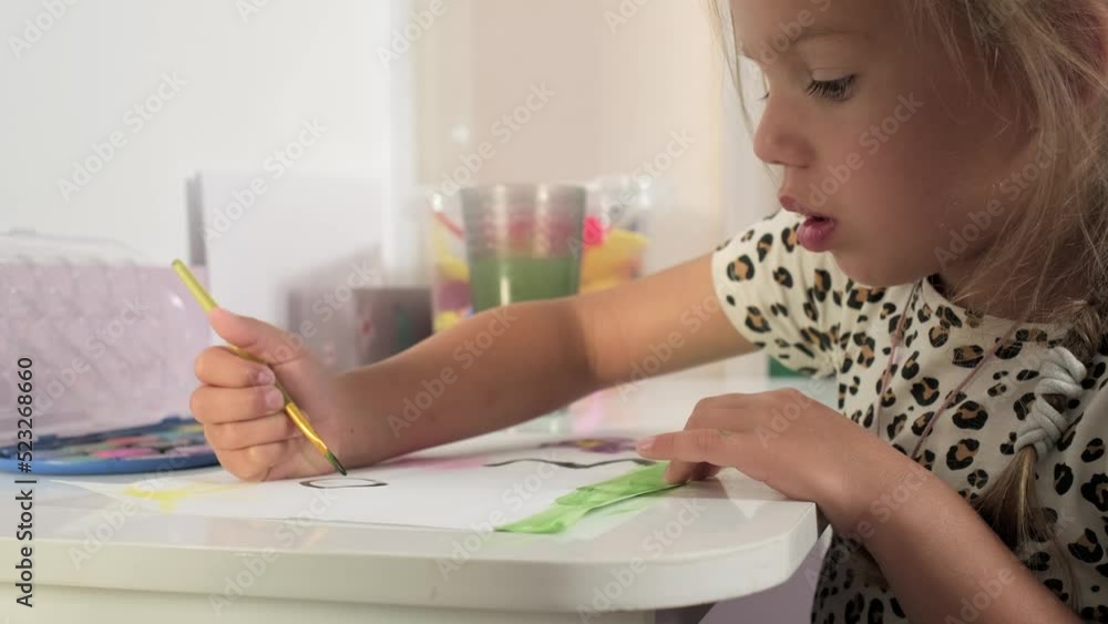 Talented Creative Child Girl Female Artist Draws with Her Hands on Paper, Using Fingers Paints Brush Creates Colorful, Kid Drawing on table at Home. Painter Creating Abstract Modern Art. Childhood Talented Creative Child Girl Female Artist Draws with Her Hands on Paper, Using Fingers Paints Brush Creates Colorful, Kid Drawing on table at Home. Painter Creating Abstract Modern Art. Childhood