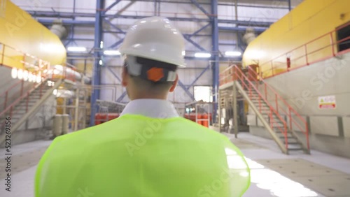 Engineer supervising industrial factory.
The executive engineer is observing and supervising the factory.
