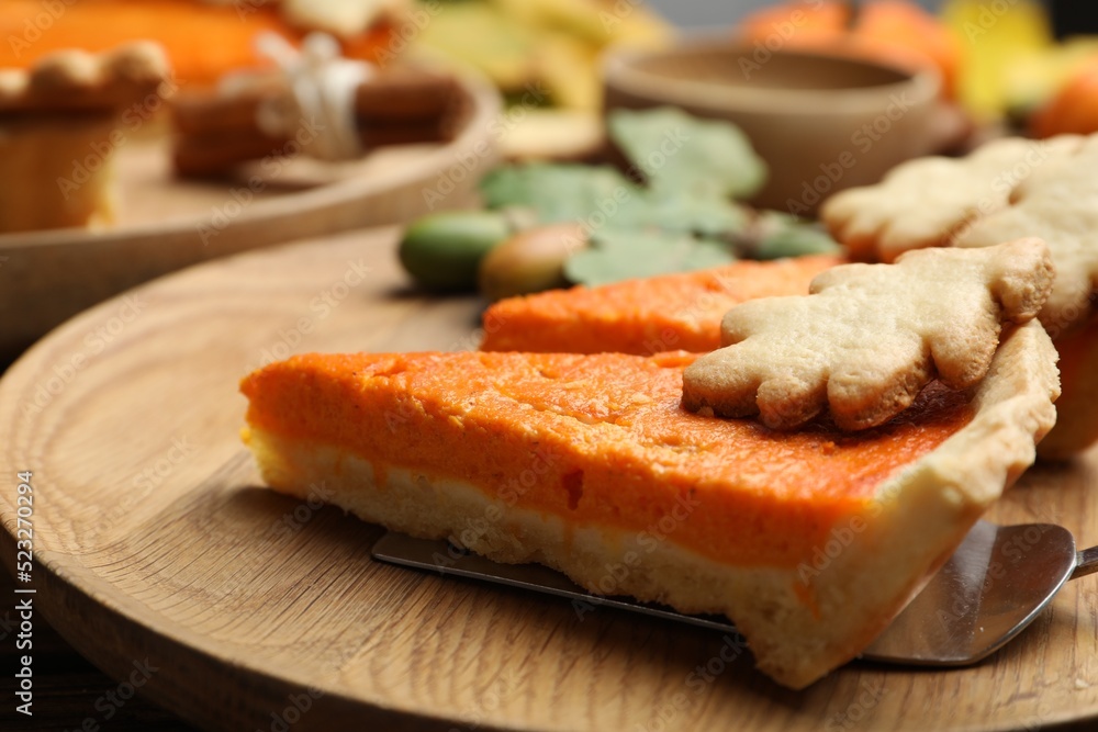 Slices of delicious homemade pumpkin pie on wooden plate, closeup Slices of delicious homemade pumpkin pie on wooden plate, closeup