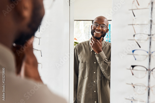 Fotografi Customer trying on glasses at an optometrist, smiling and looking confident with choice at optical store
