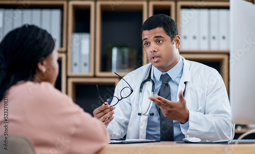 Doctor talking to patient in medical consultation, checkup and visit in clinic, hospital and healthcare center. Professional, gp and frontline worker explaining symptoms while asking woman questions photo