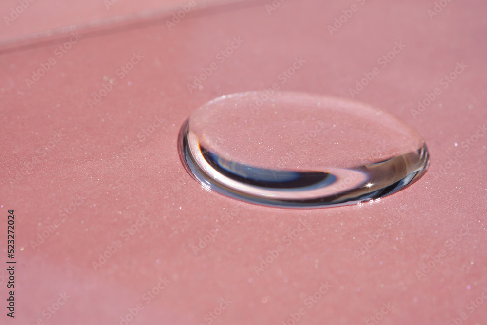 A drop of cosmetics or perfume on a pink background. A drop of cosmetics or perfume on a pink background.