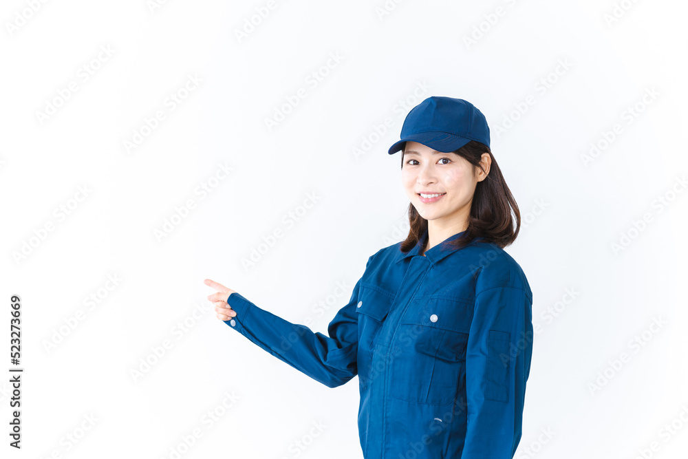作業服を着て笑顔で指差す若い女性 作業服を着て笑顔で指差す若い女性