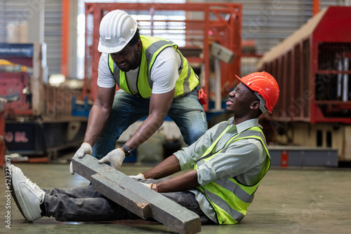 Industrial accident concept. Male african american accidents from working carrying heavy objects on legs in Industrial factory.