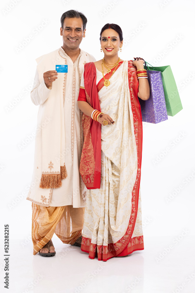 Happy bengali couple holding shooping bag and credit card in hands
