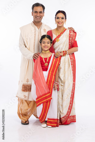 Portrait of happy bengali family in traditional clothing on occasion of durga puja celebration
