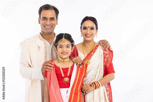 Portrait of happy bengali family in traditional clothing on occasion of durga puja celebration
