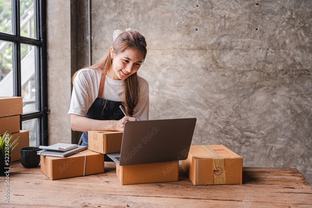 Portrait of a small business startup, SME owner, female entrepreneur, working, unboxing, checking orders online. To prepare to pack boxes for sale to SME customers online business ideas Portrait of a small business startup, SME owner, female entrepreneur, working, unboxing, checking orders online. To prepare to pack boxes for sale to SME customers online business ideas