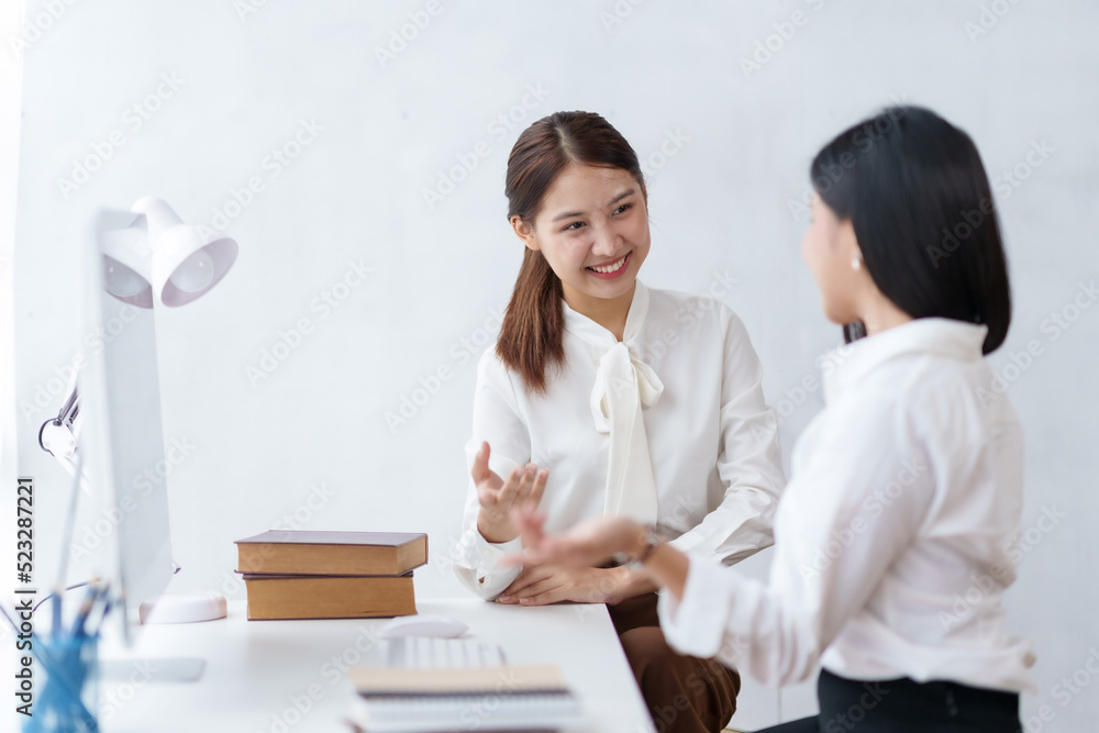Two beautiful Asian businesswomen working together using laptop computer work together consult and advise on working together to plan work in new product. Two beautiful Asian businesswomen working together using laptop computer work together consult and advise on working together to plan work in new product.
