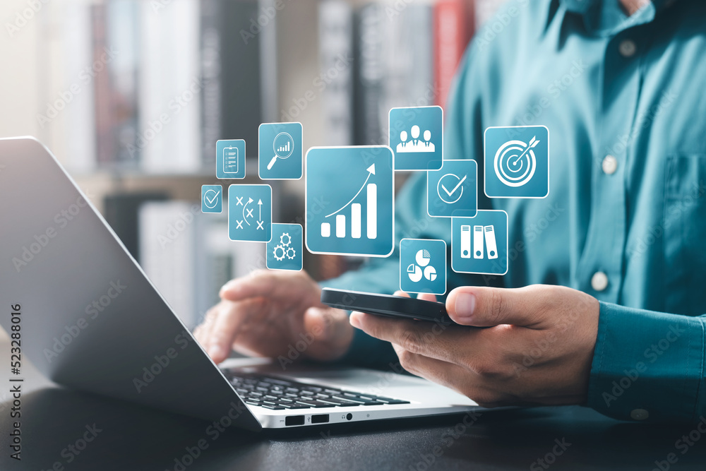 © Thapana_Studio - concept of long-term business development and management Executives looking at virtual screens business graph icon Goal setting, problem-solving, workflows, optimal business operations and innovation.