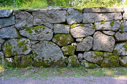 big old wall made of stones covered in moss photo