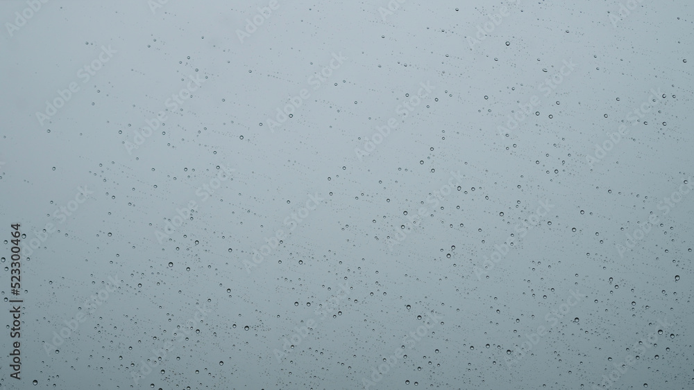 raindrops on window glass with storm clouds on background raindrops on window glass with storm clouds on background
