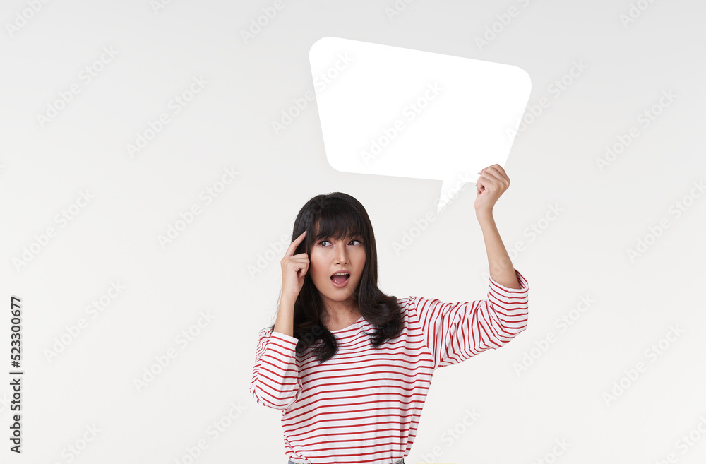 Young Asian woman holding empty speech bubble isolated on white background. Young Asian woman holding empty speech bubble isolated on white background.