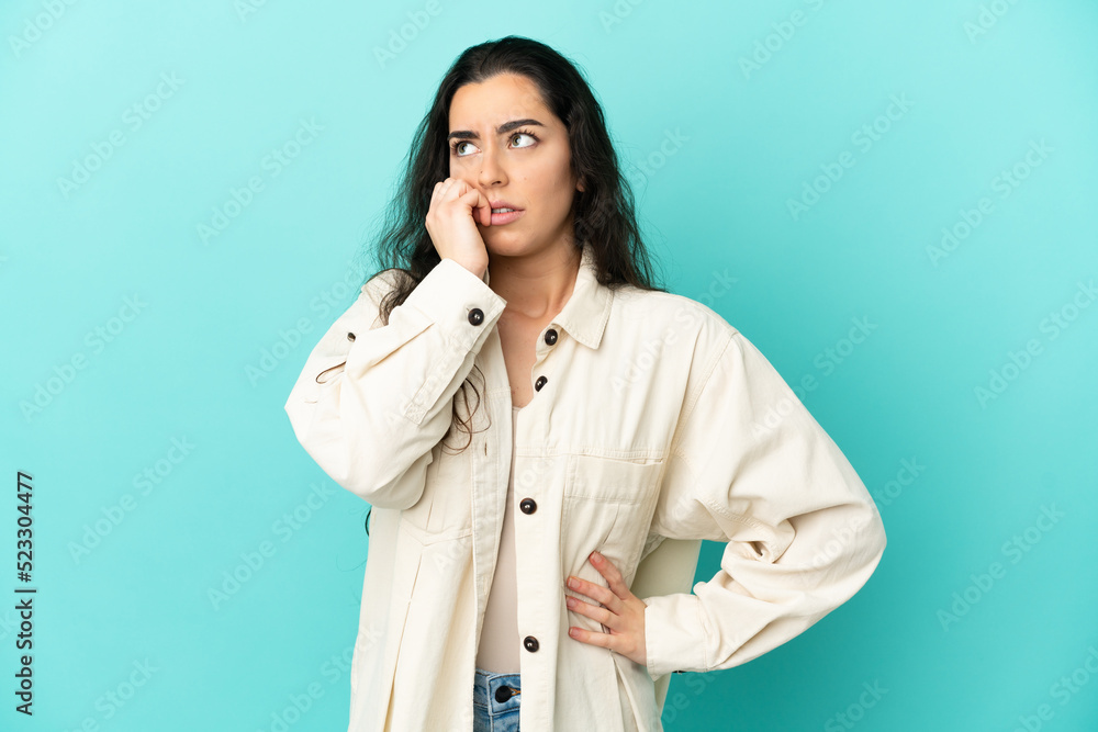 Young caucasian woman isolated on blue background is a little bit nervous Young caucasian woman isolated on blue background is a little bit nervous