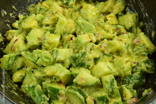 Homemade healthy avocado salad with cucumber, red onion, parsley and avocado lime dressing