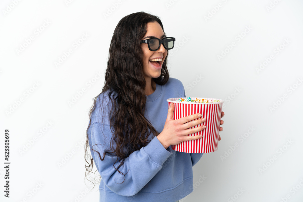 Young caucasian woman isolated on white background with 3d glasses and holding a big bucket of popcorns Young caucasian woman isolated on white background with 3d glasses and holding a big bucket of popcorns