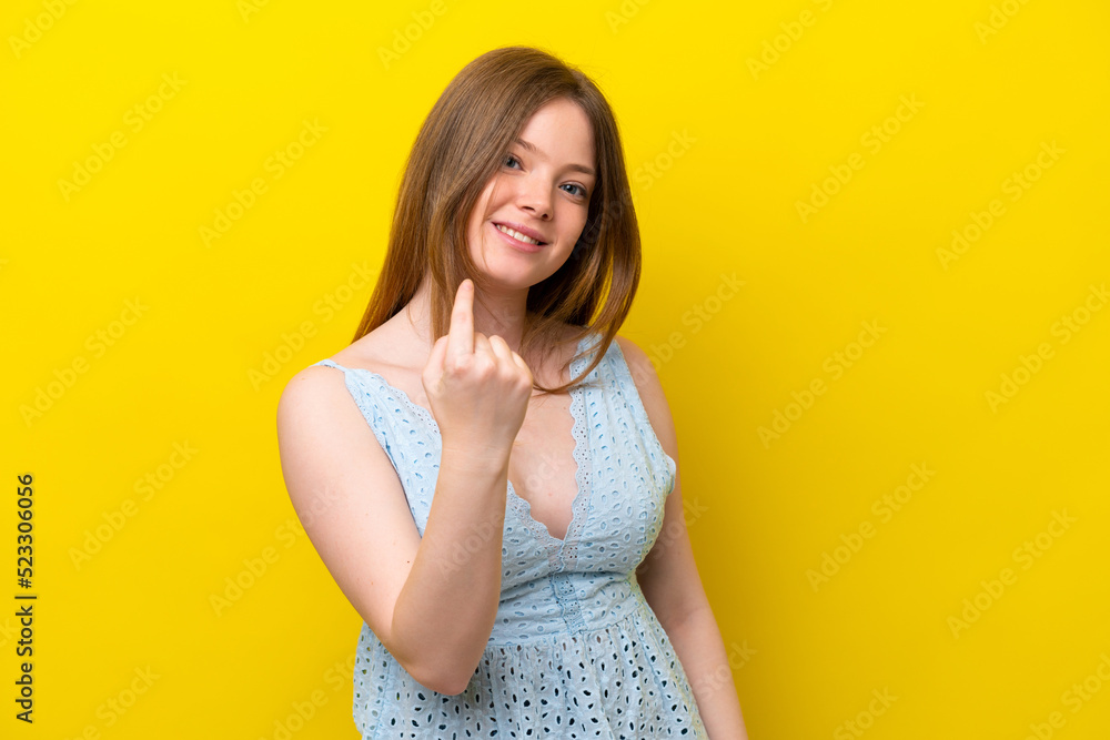 Young caucasian woman isolated on yellow background doing coming gesture Young caucasian woman isolated on yellow background doing coming gesture