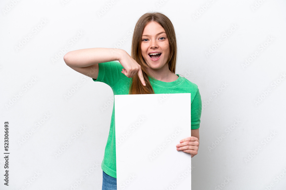 Young caucasian woman isolated on white background holding an empty placard with happy expression and pointing it Young caucasian woman isolated on white background holding an empty placard with happy expression and pointing it
