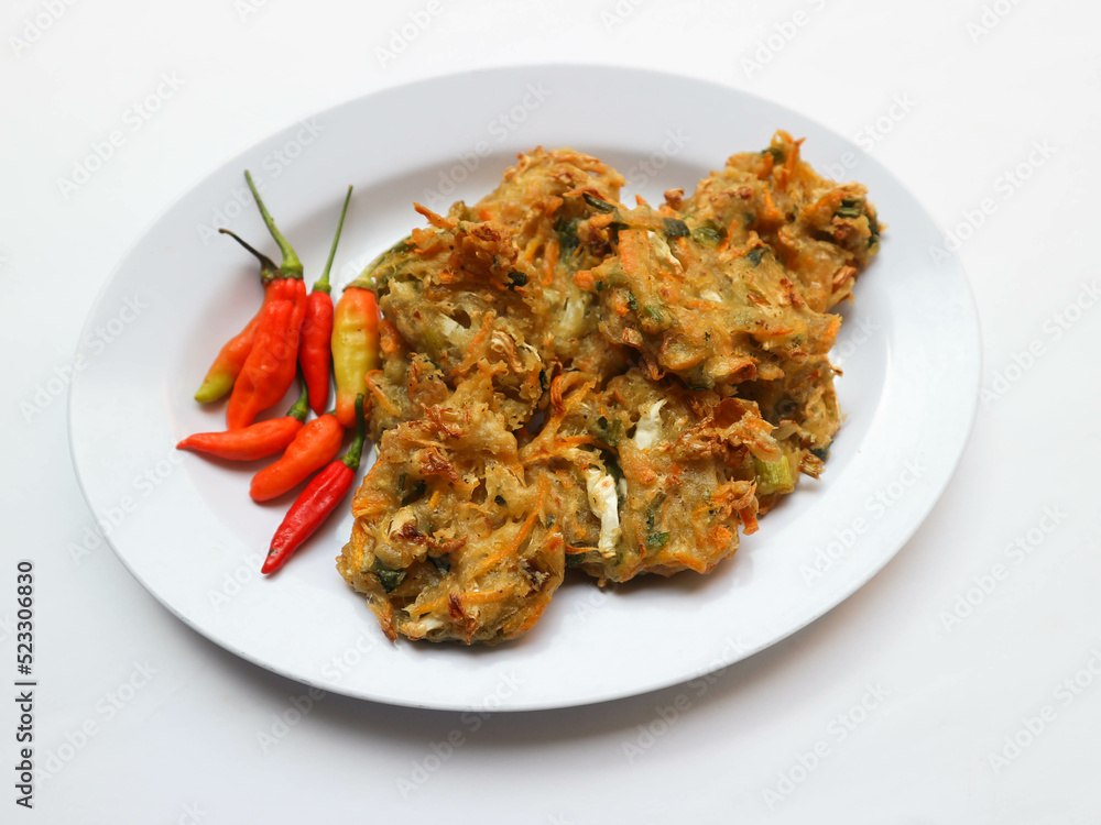 Bala-bala or Bakwan or vegetable fritter, traditional Indonesian snack, made from carrot, cabbage and bean sprouts and mix with flour and deep fried. Served with chillies and peanuts sauce