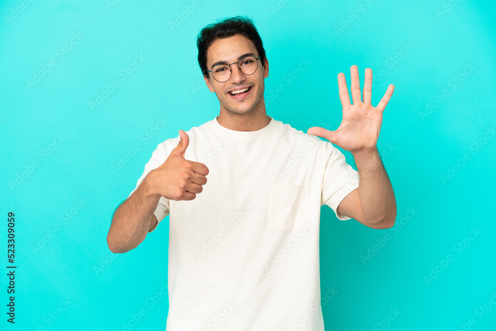 Caucasian handsome man over isolated blue background counting six with fingers Caucasian handsome man over isolated blue background counting six with fingers