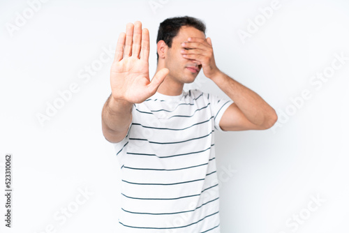 Young caucasian man isolated on white background making stop gesture and covering face