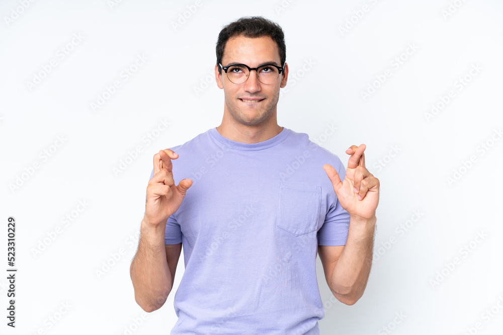 Young caucasian man isolated on white background with fingers crossing and wishing the best Young caucasian man isolated on white background with fingers crossing and wishing the best