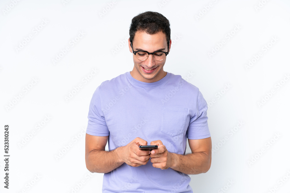 Young caucasian man isolated on white background sending a message with the mobile Young caucasian man isolated on white background sending a message with the mobile