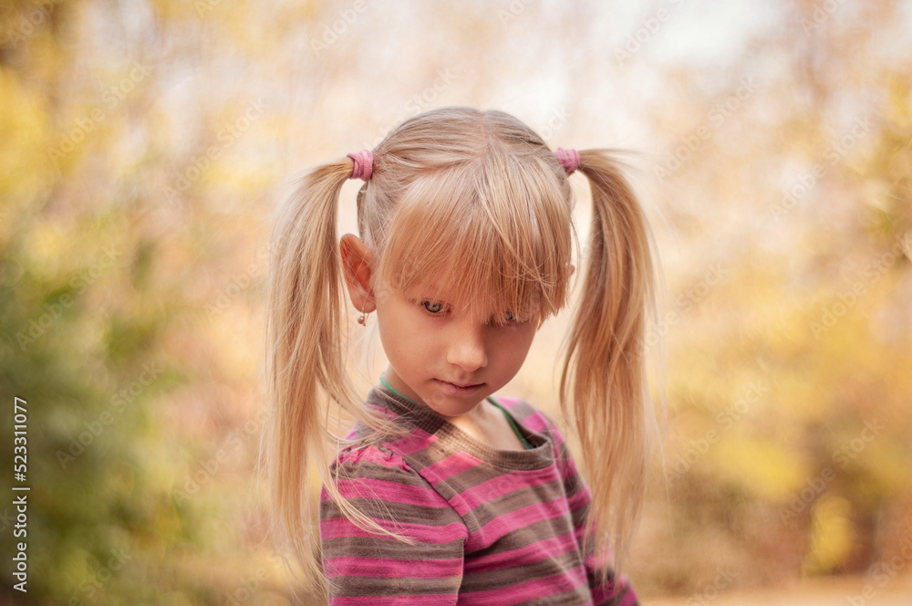 Portrait of a beautiful girl in the autumn park. Cute child with blond hair. Portrait of a beautiful girl in the autumn park. Cute child with blond hair.