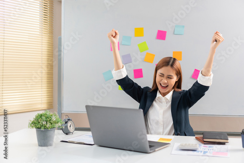 Concept of modern girl leadership, Businesswoman raises her arms in happiness after successful work