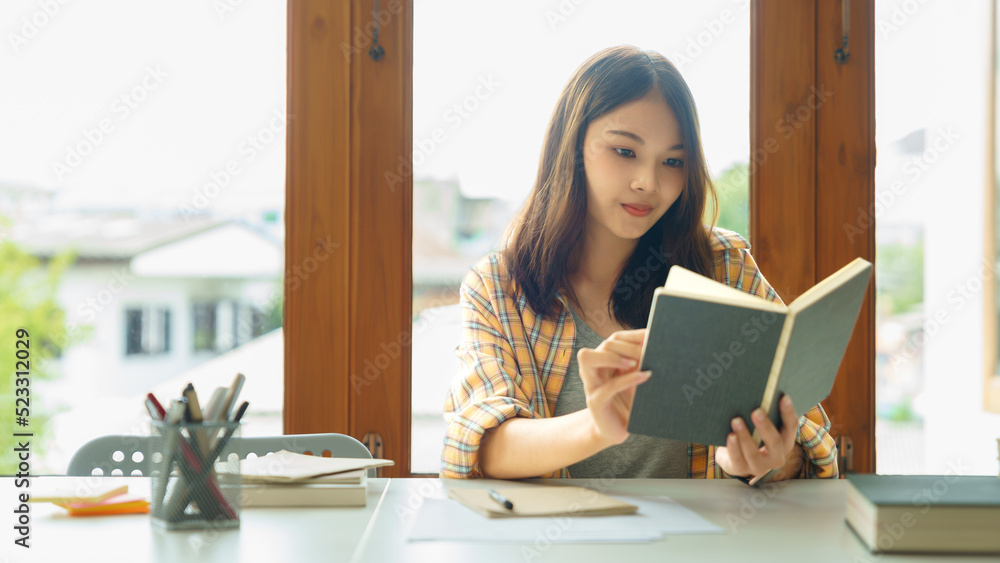Education and literacy concept, College student girl is reading textbook in college library Education and literacy concept, College student girl is reading textbook in college library