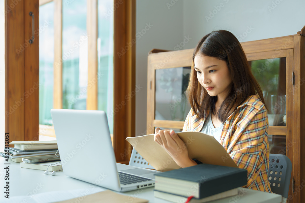 Education and literacy concept, College student girl reading lesson on laptop and taking notes Education and literacy concept, College student girl reading lesson on laptop and taking notes