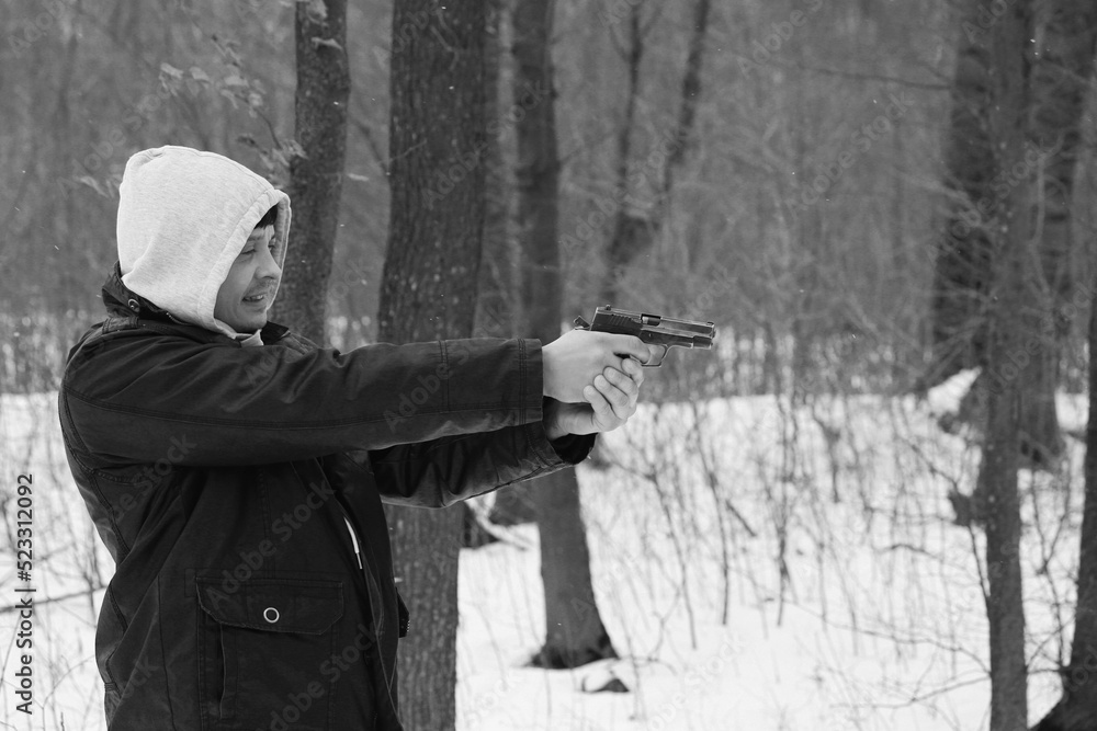 Fototapeta premium A man shooting by the pistol in the forest