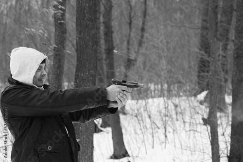 A man shooting by the pistol in the forest