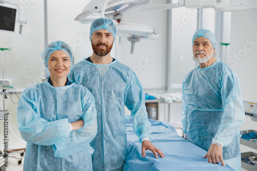Team of professional surgeons standing in operating room before surgery