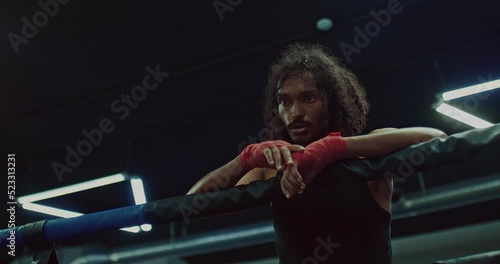 dark-skinned man on ring after MixFight match or hard training in fight club, portrait, 4K, Prores photo