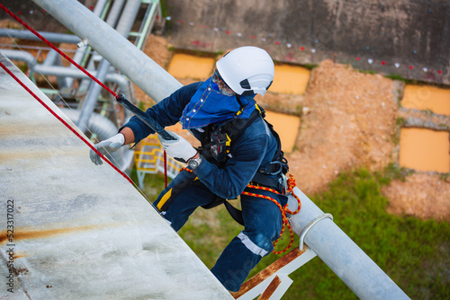 Top view male worker inspection wearing safety first harness rope safety line working at a high place on tank roof spherical