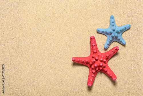 Two starfishes at the beach sand.