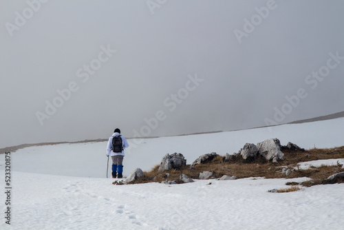 Hiker on the summit of a mountain with snow