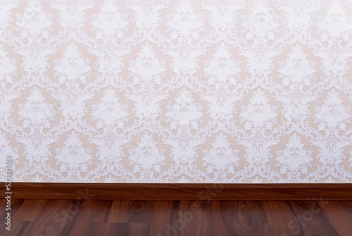 Wooden parquet floor and wallpaper on a wall