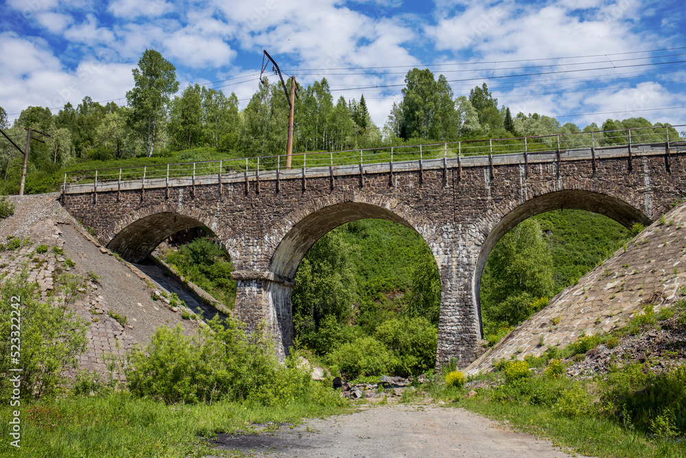 Old road bridge in knightly style. Beautiful summer landscape in Europe. Horizontal photos of architectural structures.