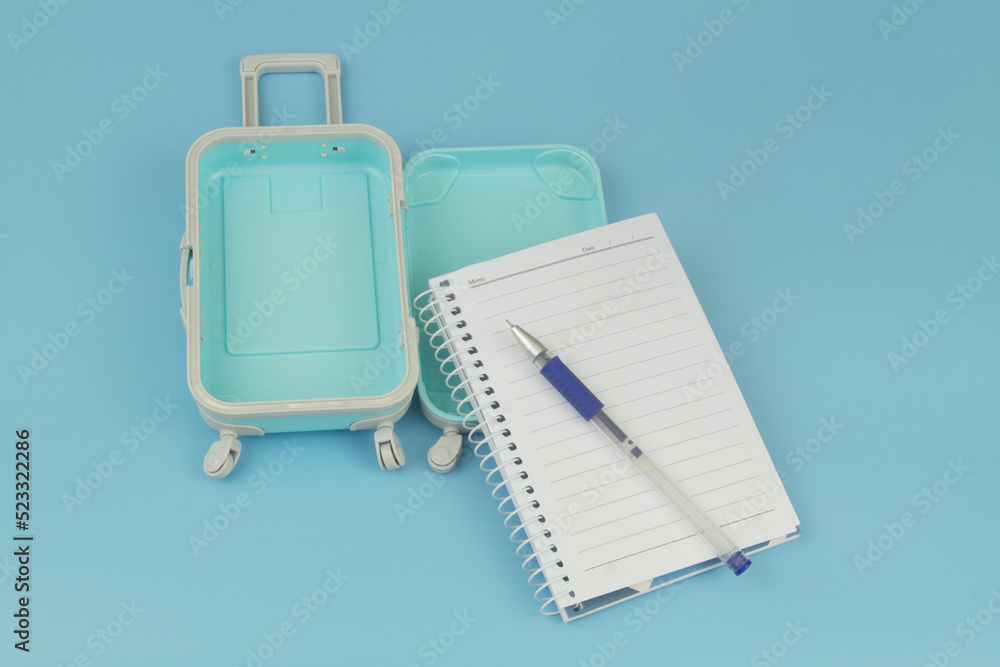 What take for travel, necessary things in trip concept. Open travel suitcase with notebook and pen. What take for travel, necessary things in trip concept. Open travel suitcase with notebook and pen.