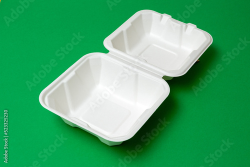 Open clean biodegradable bento box on green background. Selective focus. Images for articles about environmental friendliness, cakes.