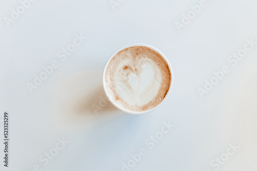 Cappuccino with a beautiful foam in a cup to go on a white background. Delicious cappuccino with alternative vegetable milk